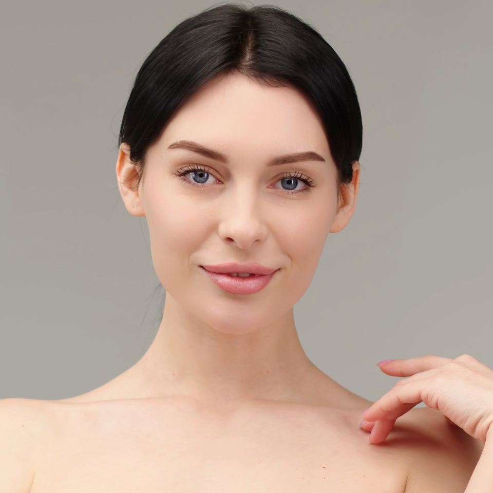 Portrait of a young woman isolated on a light background. Skin care. Beautiful female model with perfectly clean fresh skin. Natural beauty and cosmetology concept