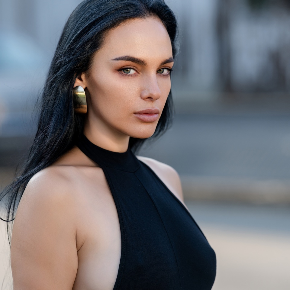 Portrait of Beautiful brunette woman posing on the street. Close-up Fashion woman portrait of young pretty trendy girl, summer street fashion. High fashion close up portrait of elegant woman outdoor.